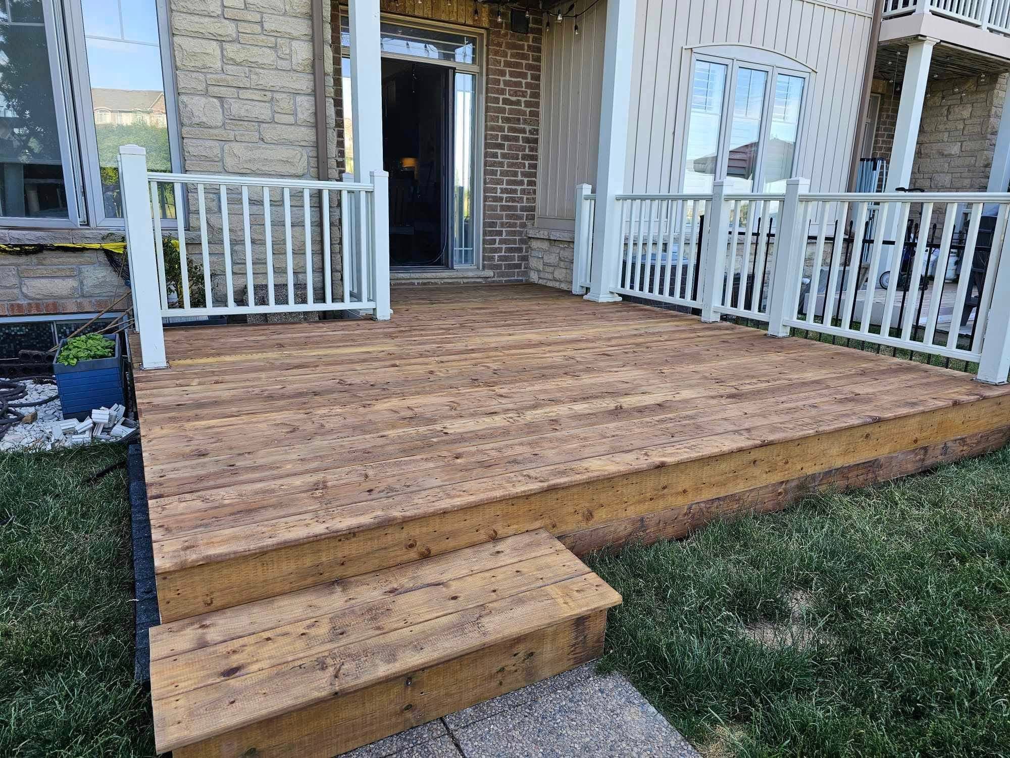 Finished cedar front deck with white railings installed by Welbanks