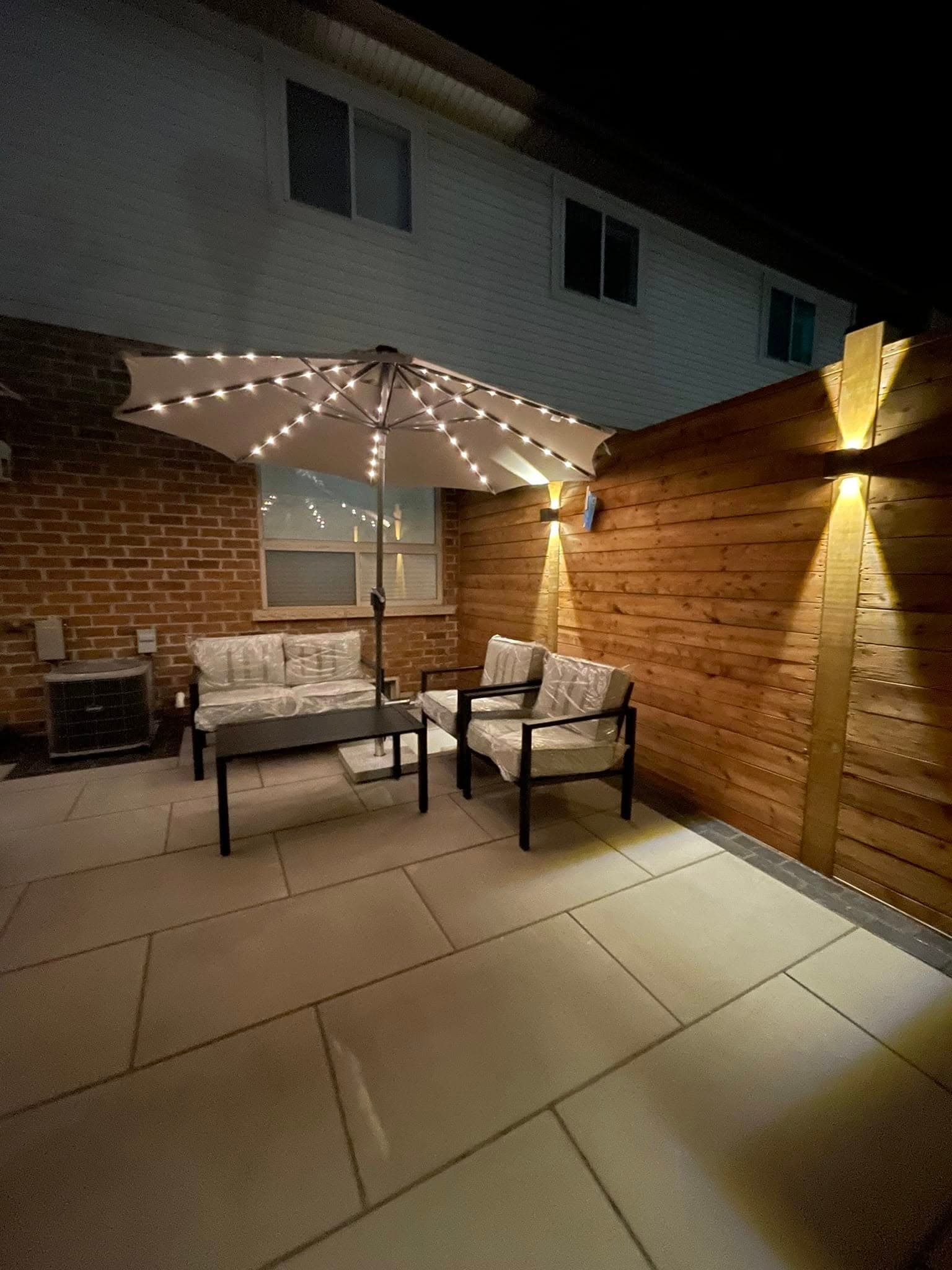Night view of patio oasis with lit cedar feature wall