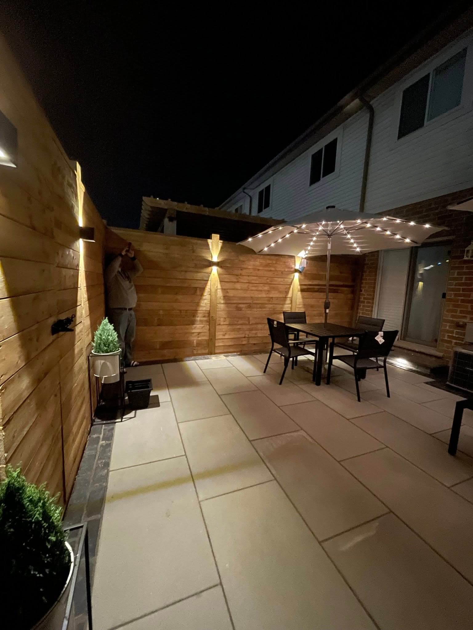 Evening shot of the dining area with downlights on the cedar wall